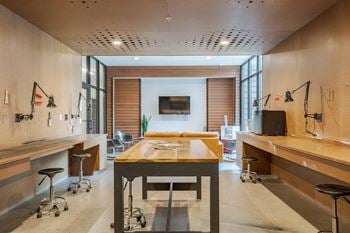 A modern kitchen with a long table and bar stools.